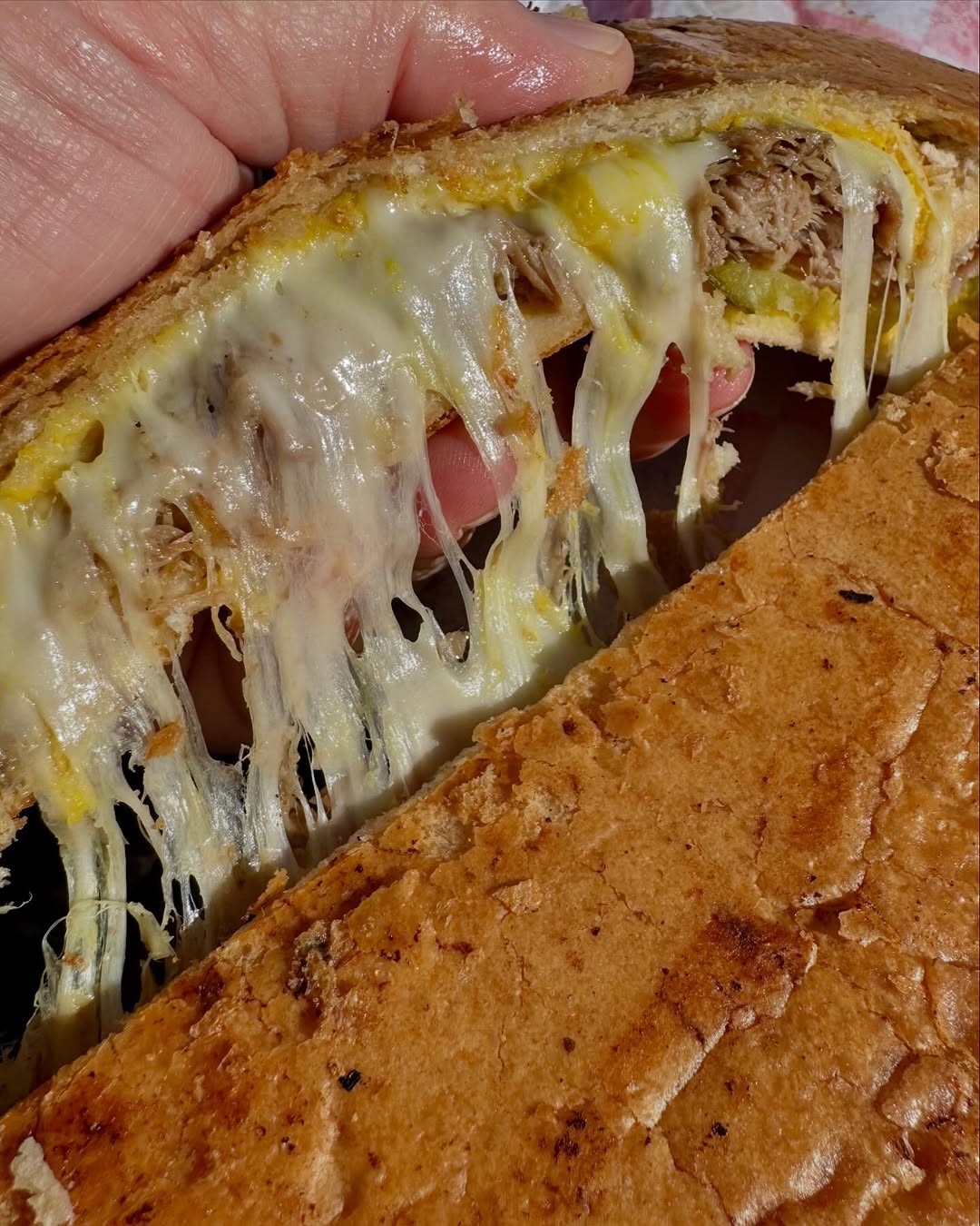 Cheese pull from a fresh La Cocina Cubana Cuban sandwich