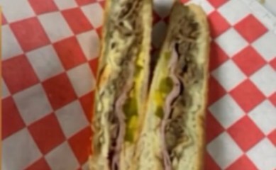 Cuban sandwich sliced open on checkered paper